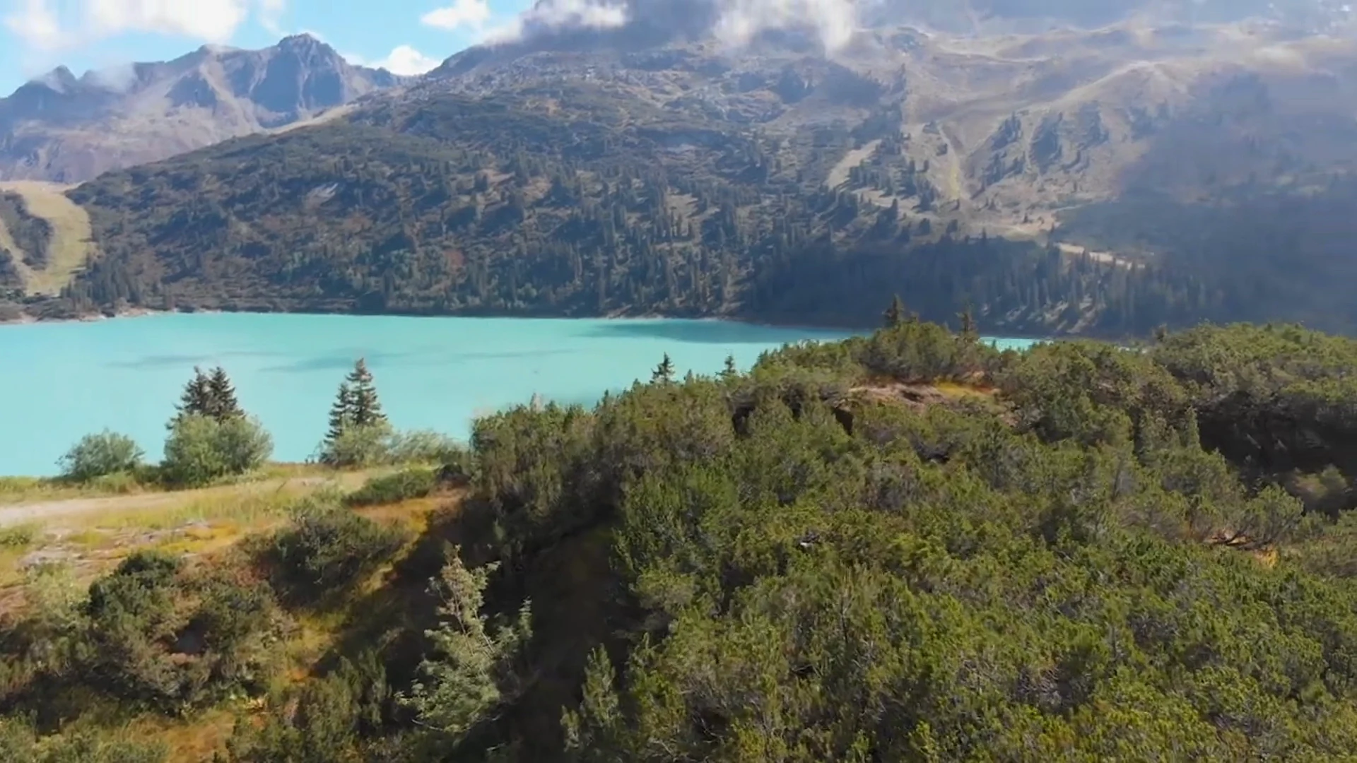Blick über einen türkisen Stausee in den österreichischen Bergen